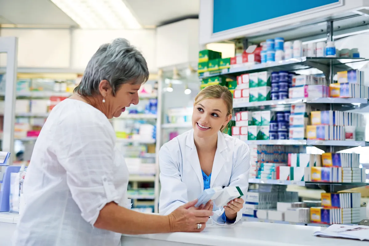 Care4All pharmacist explaining a prescription to a patient at the pharmacy counter