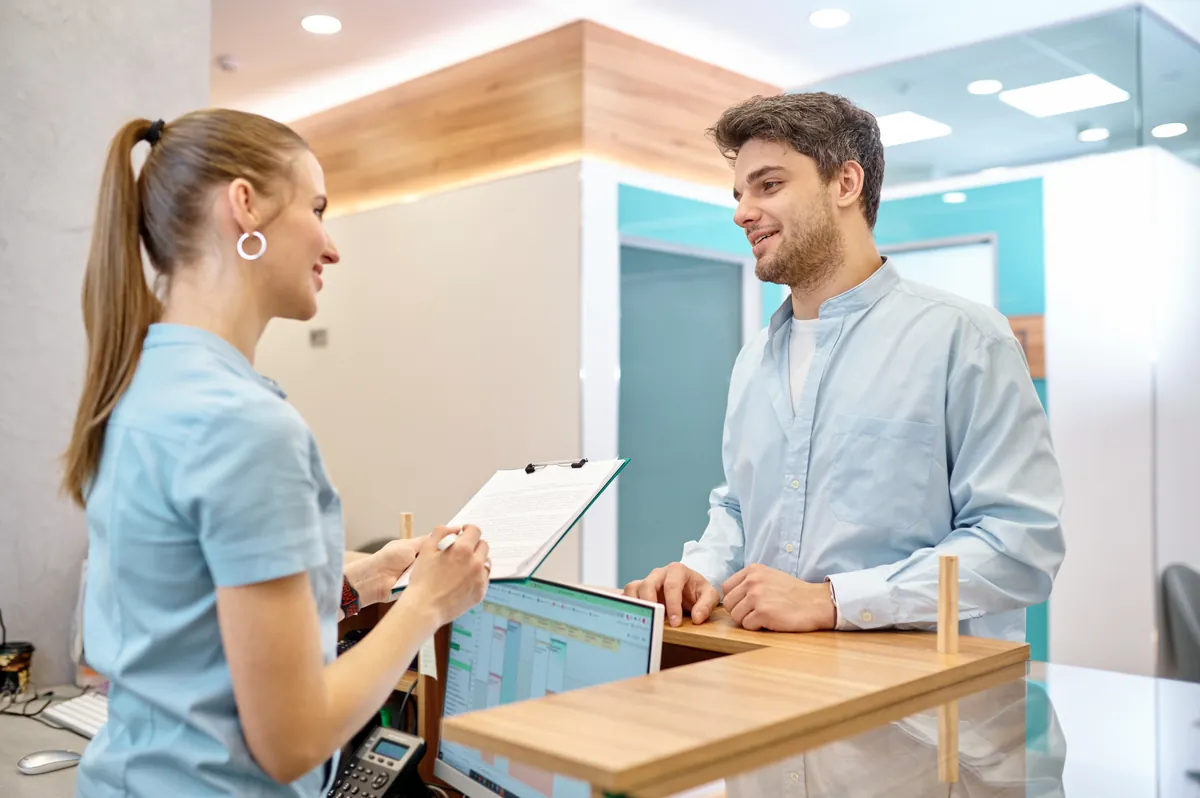 Friendly Care4All receptionist helping a patient book care